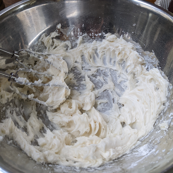 Mixing butter with sifted sugar in small batches